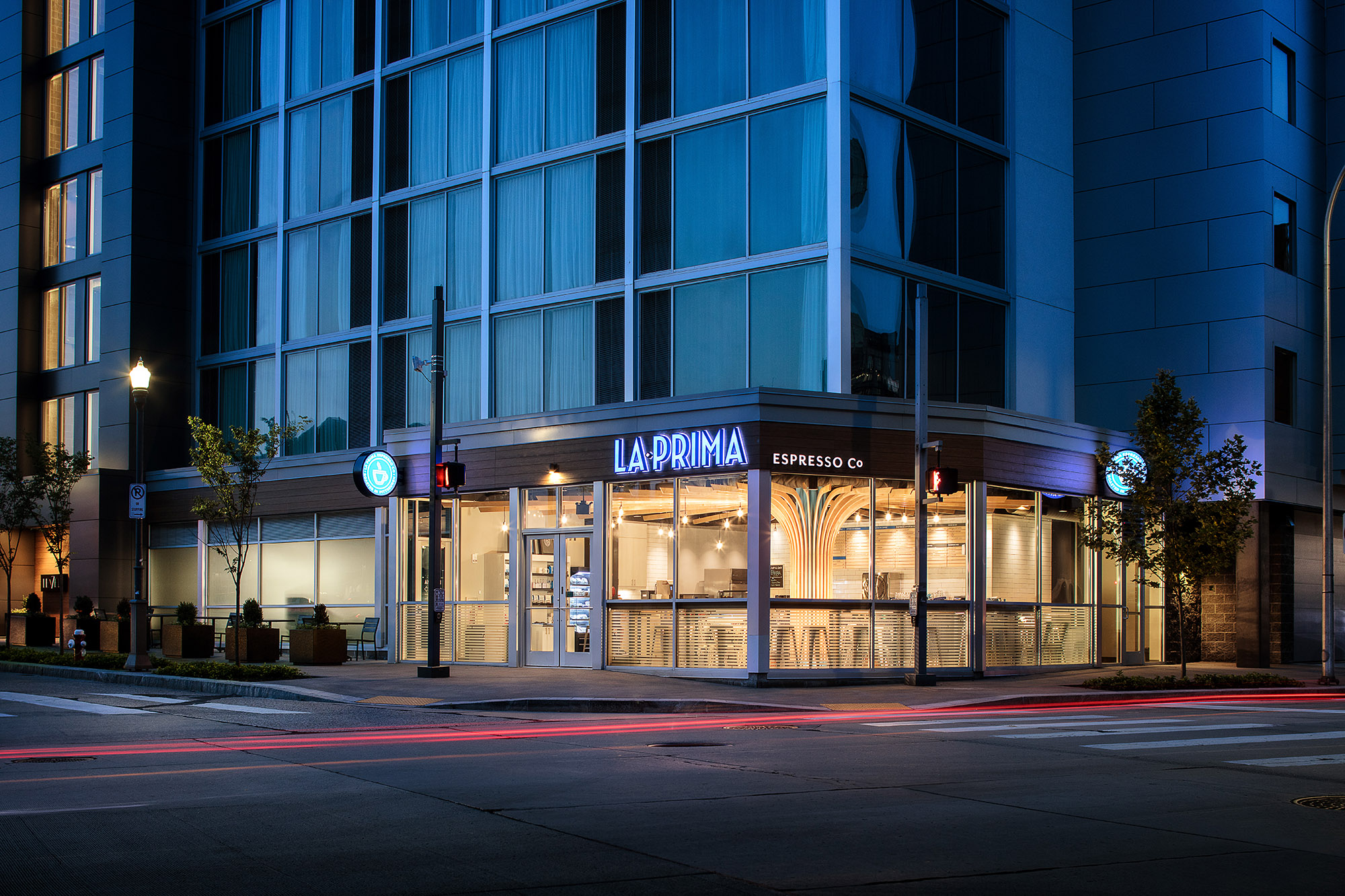 Photo of high rise building with coffee shop brightly lit in the store front